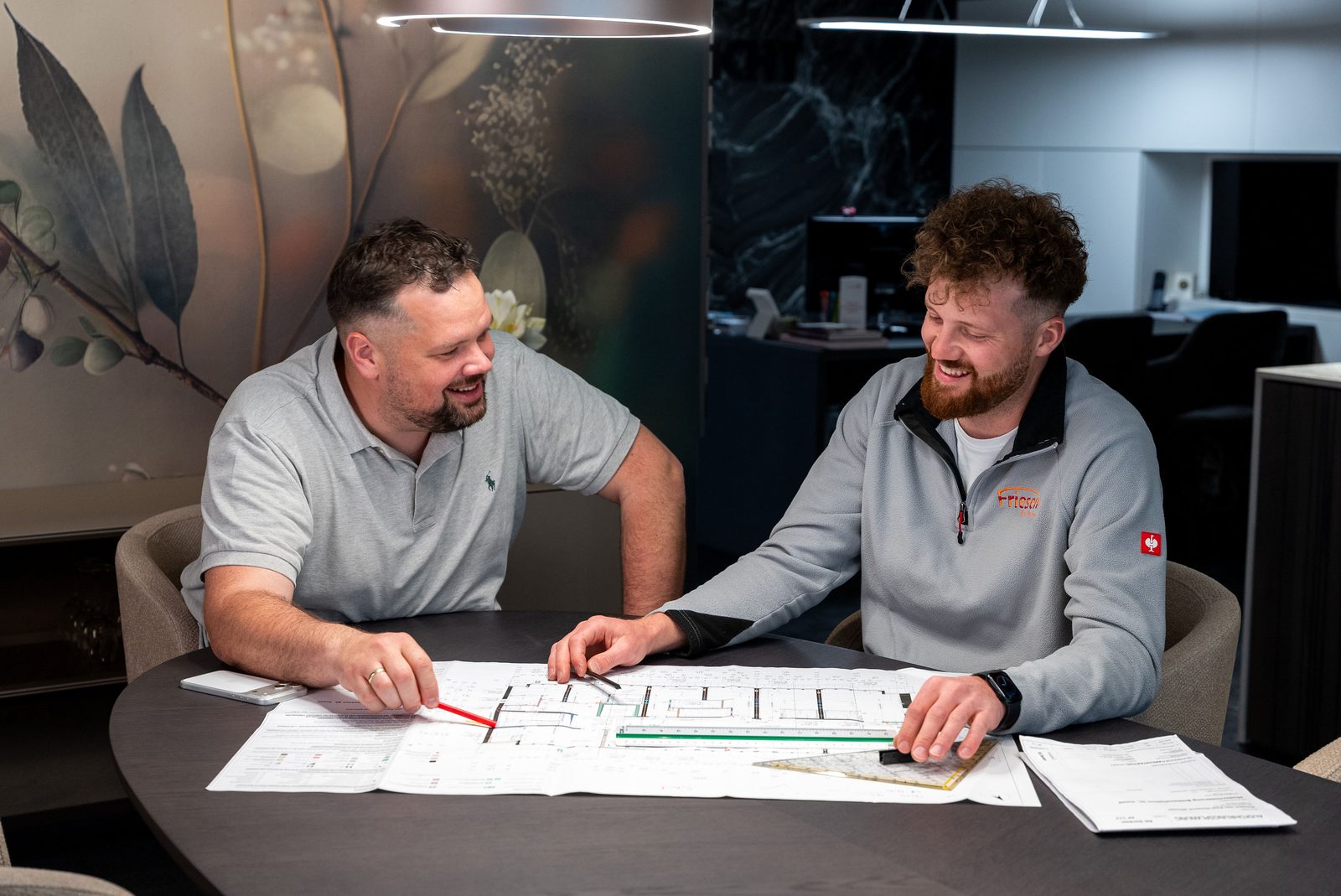 Thomas Friesen (links) und James Friesen (rechts) am Besprechungstisch, im Gespräch über die Grundrisse des Projekts in Tuningen